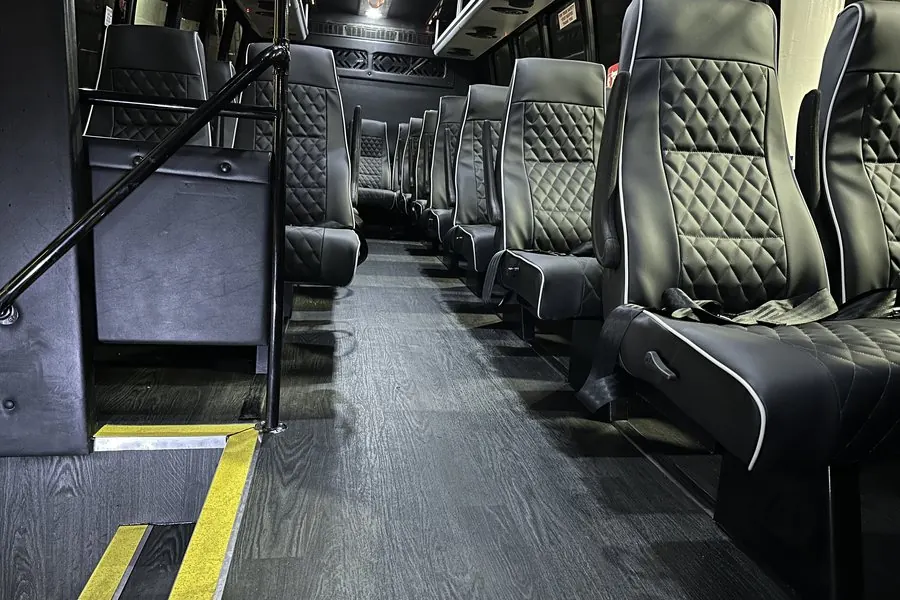 Minibus cabin with quilted black leather seats and a wood-look floor