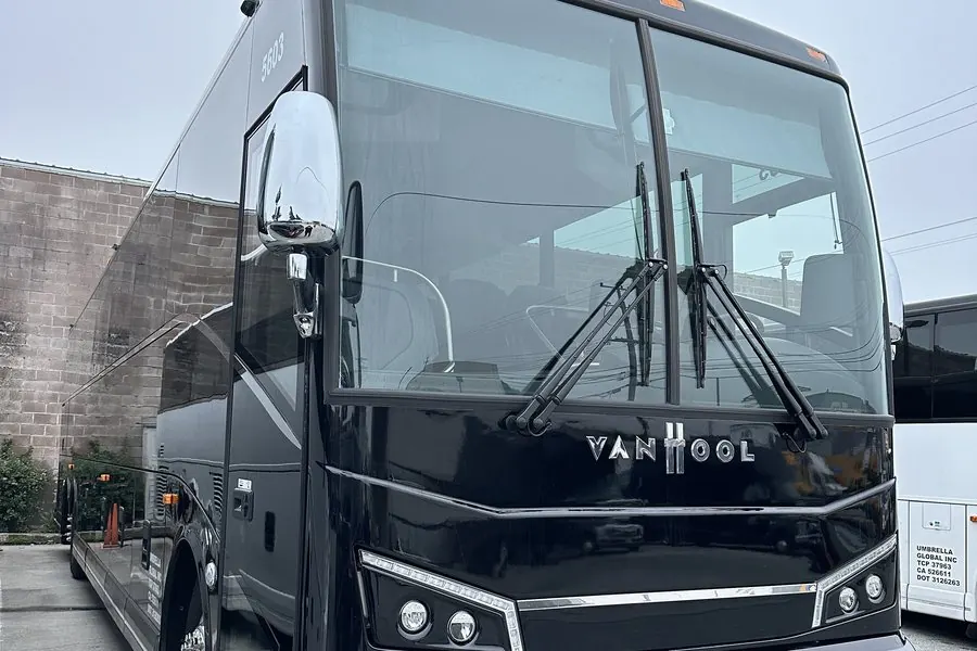 Front of a black Van Hool CX45 56-passenger motorcoach at the Umbrella Global Bus yard in South San Francisco