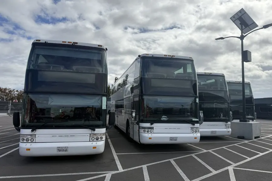 Three white Van Hool TDX25 Astromega double-decker coaches owned by Umbrella Global Bus, parked side by side
